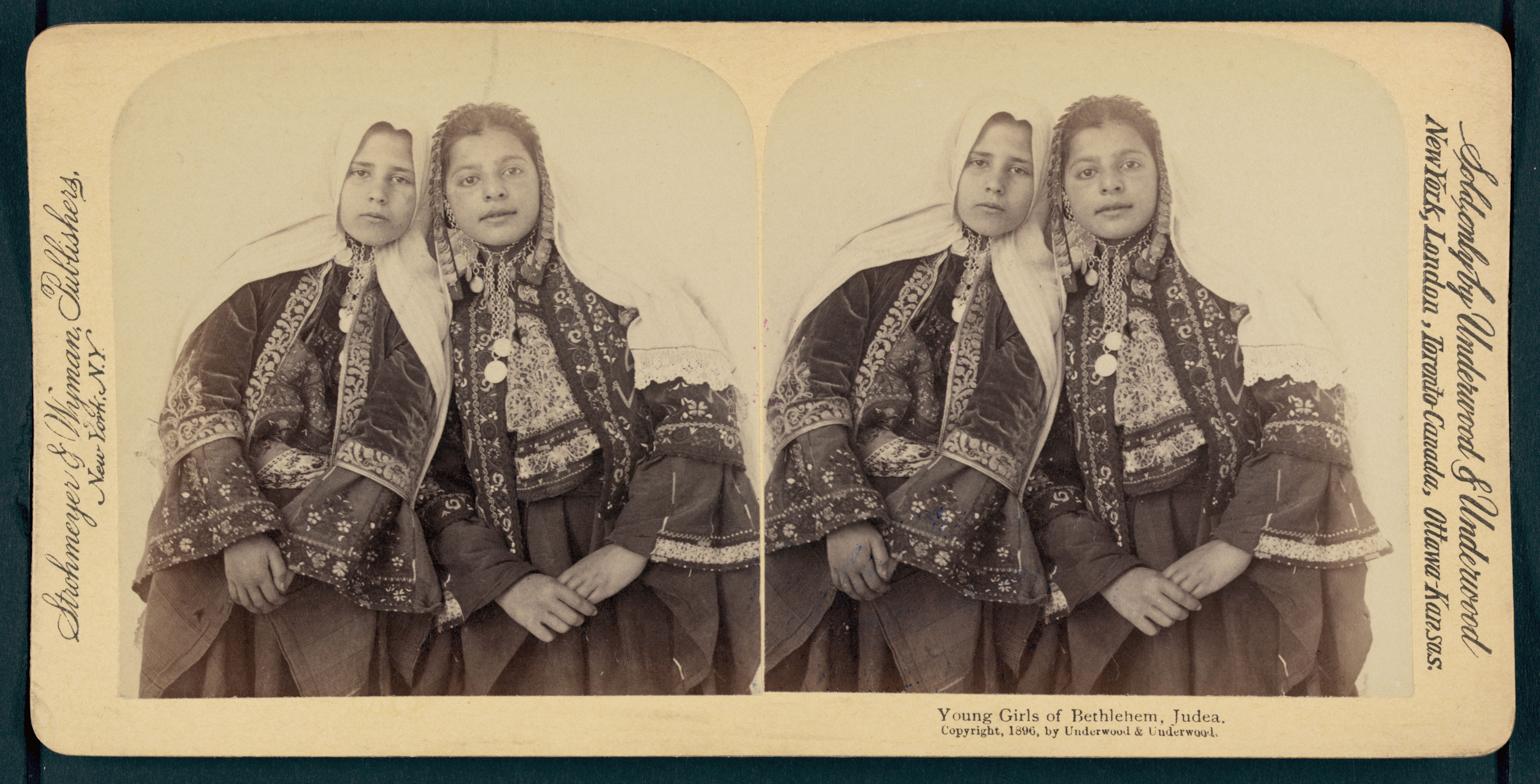 Stereoscopic photograph of two young girls from Bethlehem, Judea, wearing traditional clothing and head coverings.