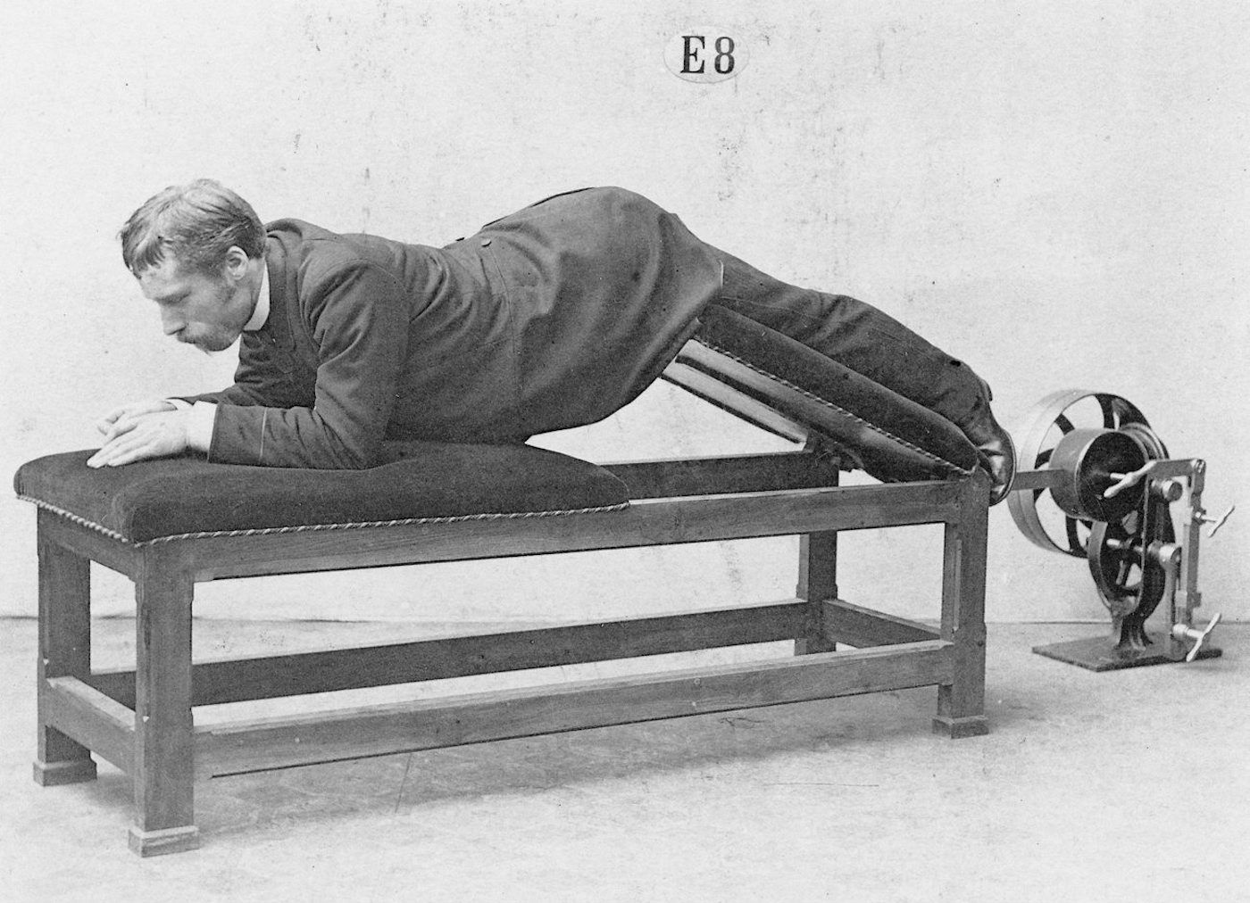 Vintage photograph of a man using exercise equipment.