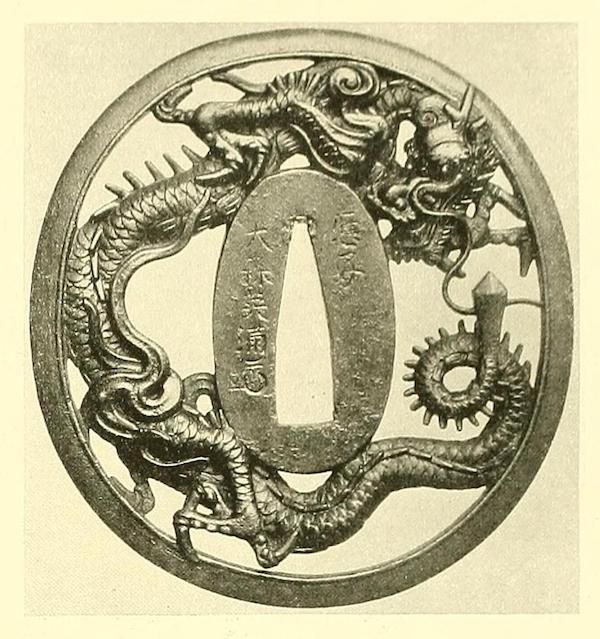 A detailed image of a Japanese tsuba, a sword guard, featuring two intertwined dragons around a central opening.
