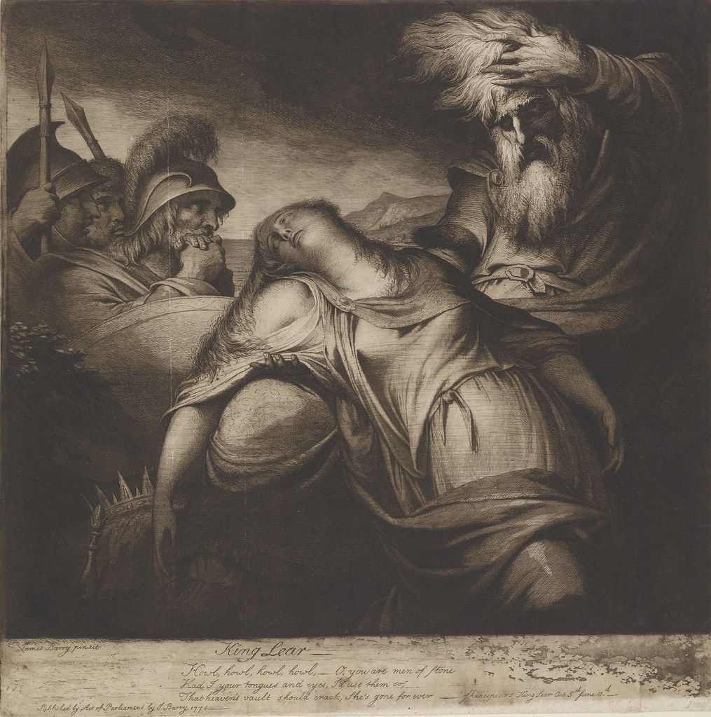 A dramatic, monochromatic engraving depicting a scene from Shakespeare's *King Lear*. The central figure is a woman, likely Cordelia, lying prone and seemingly lifeless. She is draped in flowing garments, and her head is cradled in the arms of a man, presumably King Lear, who is kneeling beside her. Lear is depicted with a long, flowing beard and wearing a helmet, suggesting a warrior or king. His face is contorted in grief and despair. Around them are several other figures, including soldiers in armor. One soldier is attempting to restrain Lear, while others look on with expressions of concern or sorrow. The background features a stormy landscape with dark clouds and a sense of foreboding.