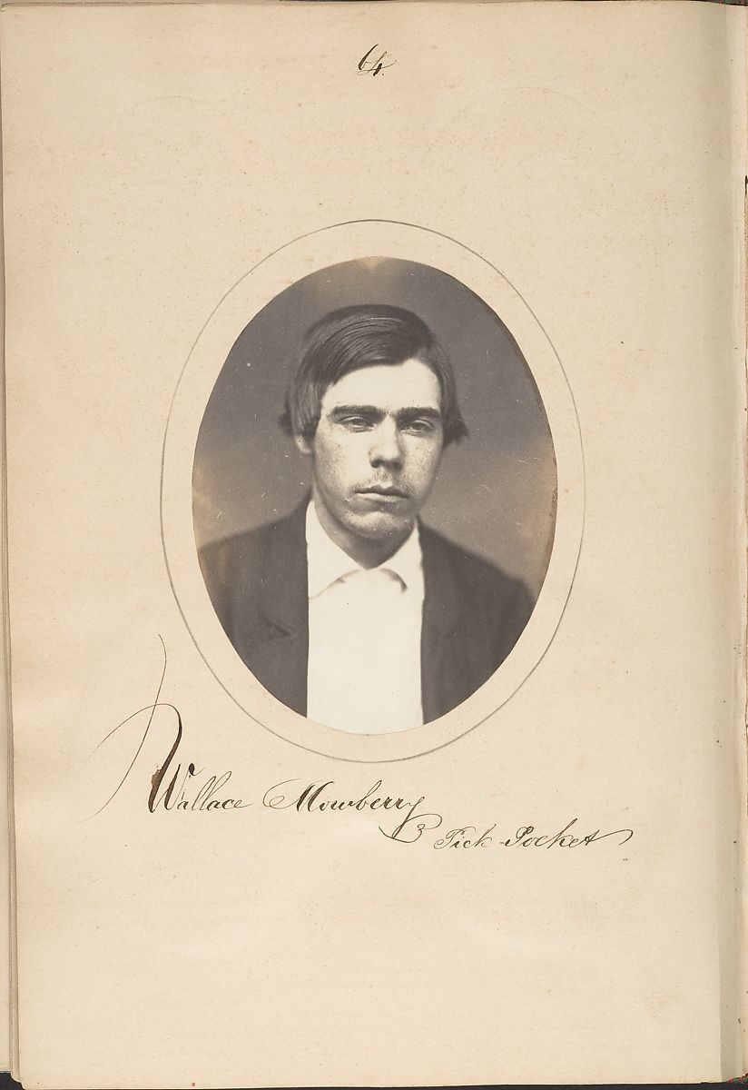 Vintage photograph of Wallace Mumford, a man in a dark suit, with a handwritten signature below.