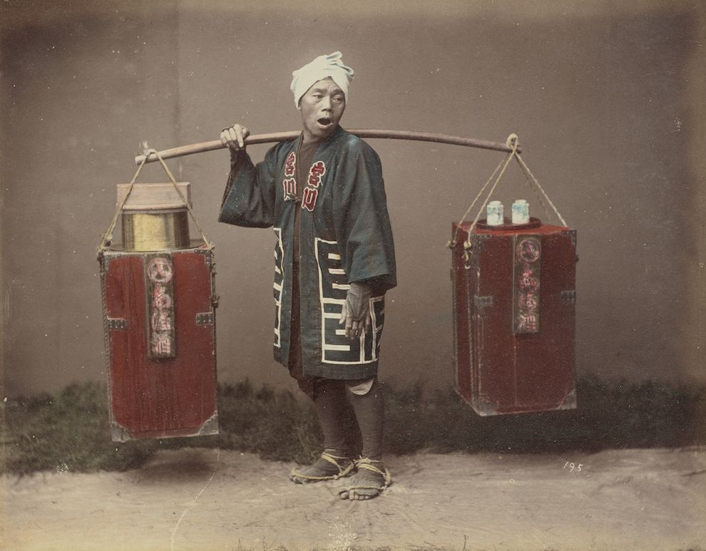 Vintage photograph of a Chinese man carrying water buckets.