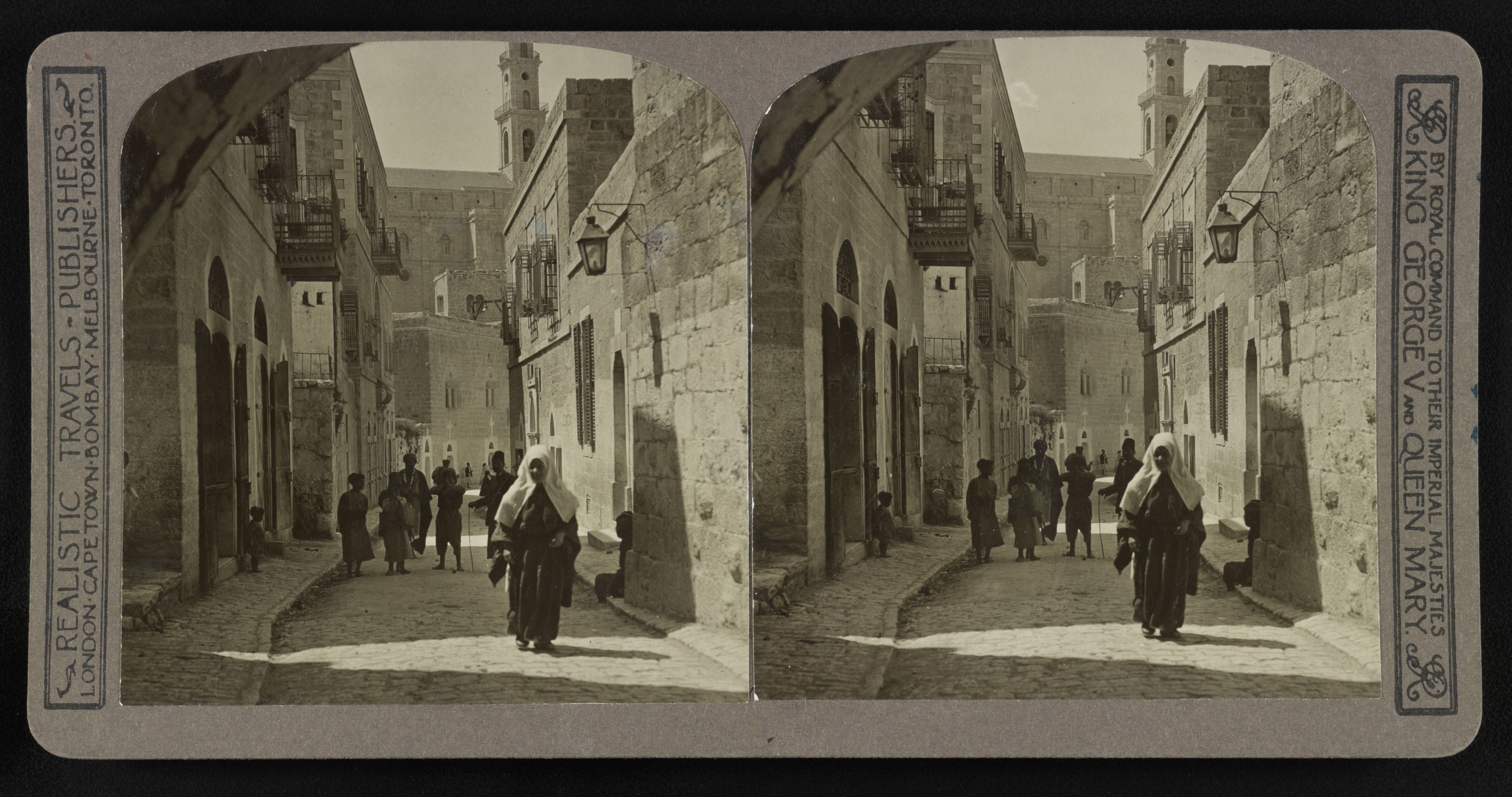 Stereoscopic photograph of a narrow street with old stone buildings and a person walking away.