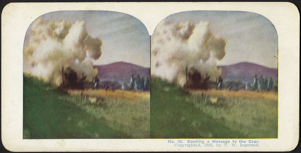 Stereoscopic photograph of a field with smoke rising and hills in the background, labeled 'Sending a Message to the Czar' and dated 1905.