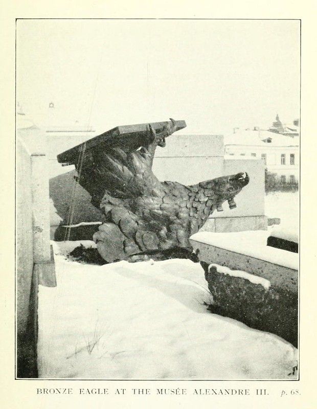 A vintage black and white photograph of a bronze eagle sculpture at the Musée Alexandre III, covered in snow.