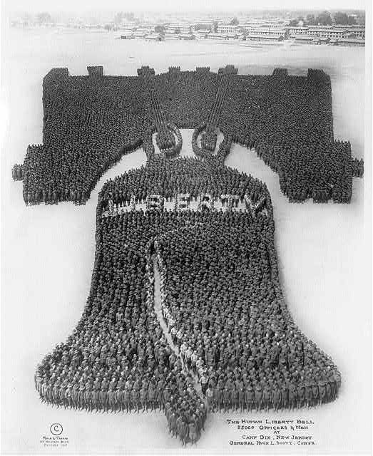 A black and white photograph of a massive formation of soldiers arranged to resemble the Liberty Bell at Camp Dix, New Jersey.