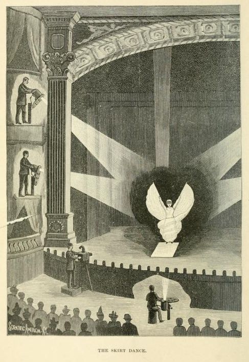 Vintage illustration of 'The Skirt Dance' in an ornate theater with a dancer, audience, and musicians.