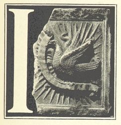 A black and white image of a stone carving of the letter 'I' with intricate designs.