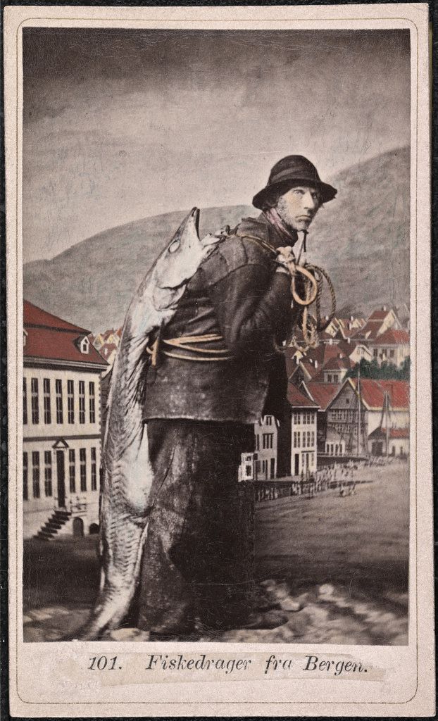 A sepia-toned vintage photograph of a fishmonger from Bergen, Norway, carrying a large fish over his shoulder. The background shows colorful buildings and rolling hills.