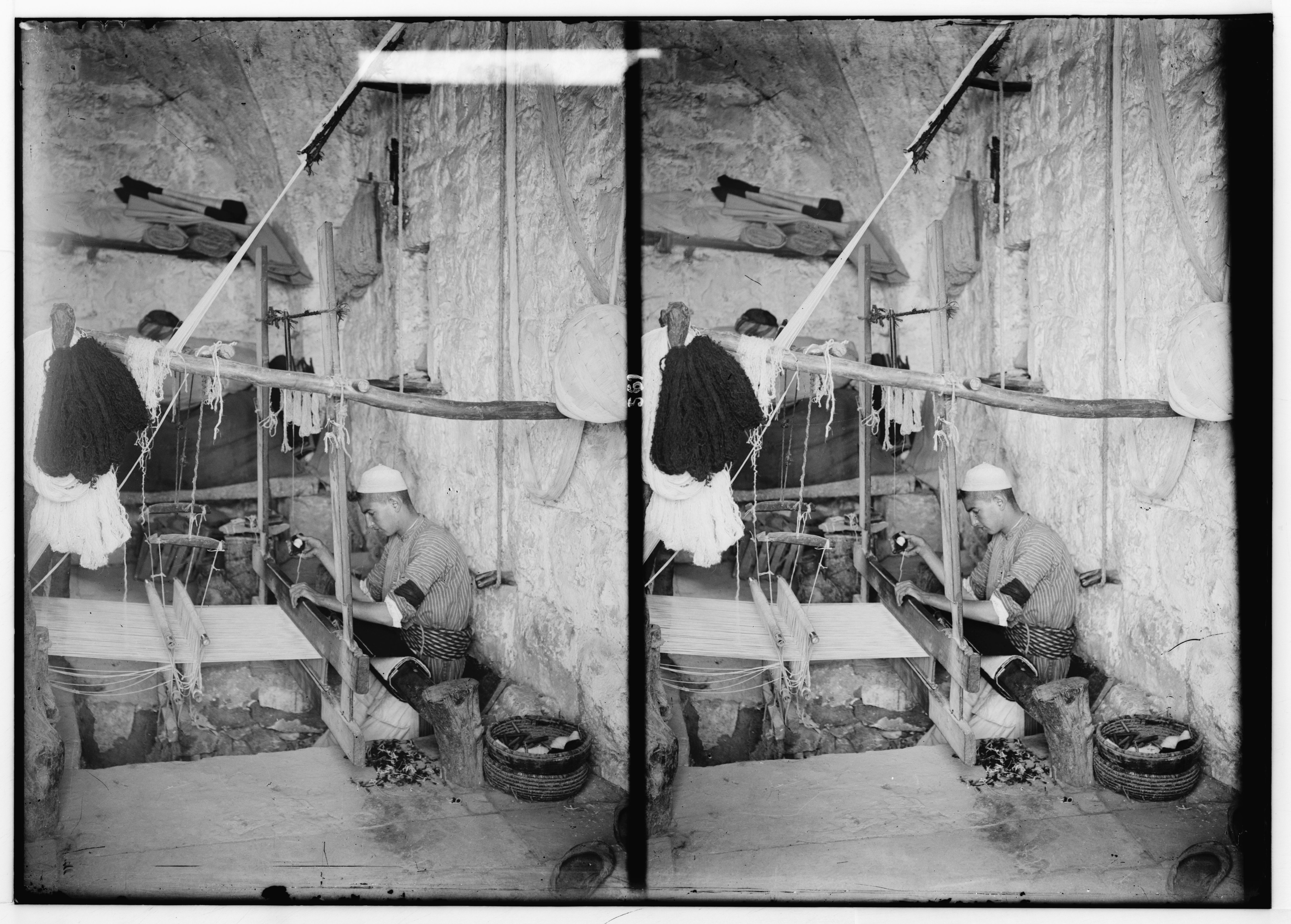 Stereoscopic photograph of a person working at a silk-reeling machine in a workshop.