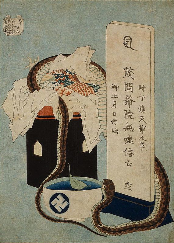 A Japanese woodblock print featuring a black helmet encircled by a snake and a stone lantern, with a fan and a scroll with Japanese calligraphy in the background.