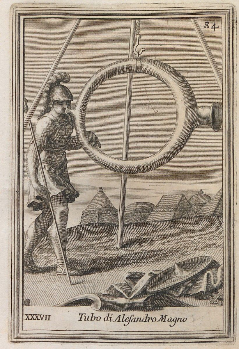 A black and white engraving depicting a soldier blowing a large curved trumpet in a military encampment. The scene is labeled 'Tubo di Alessandro Magno' (Trumpet of Alexander the Great).