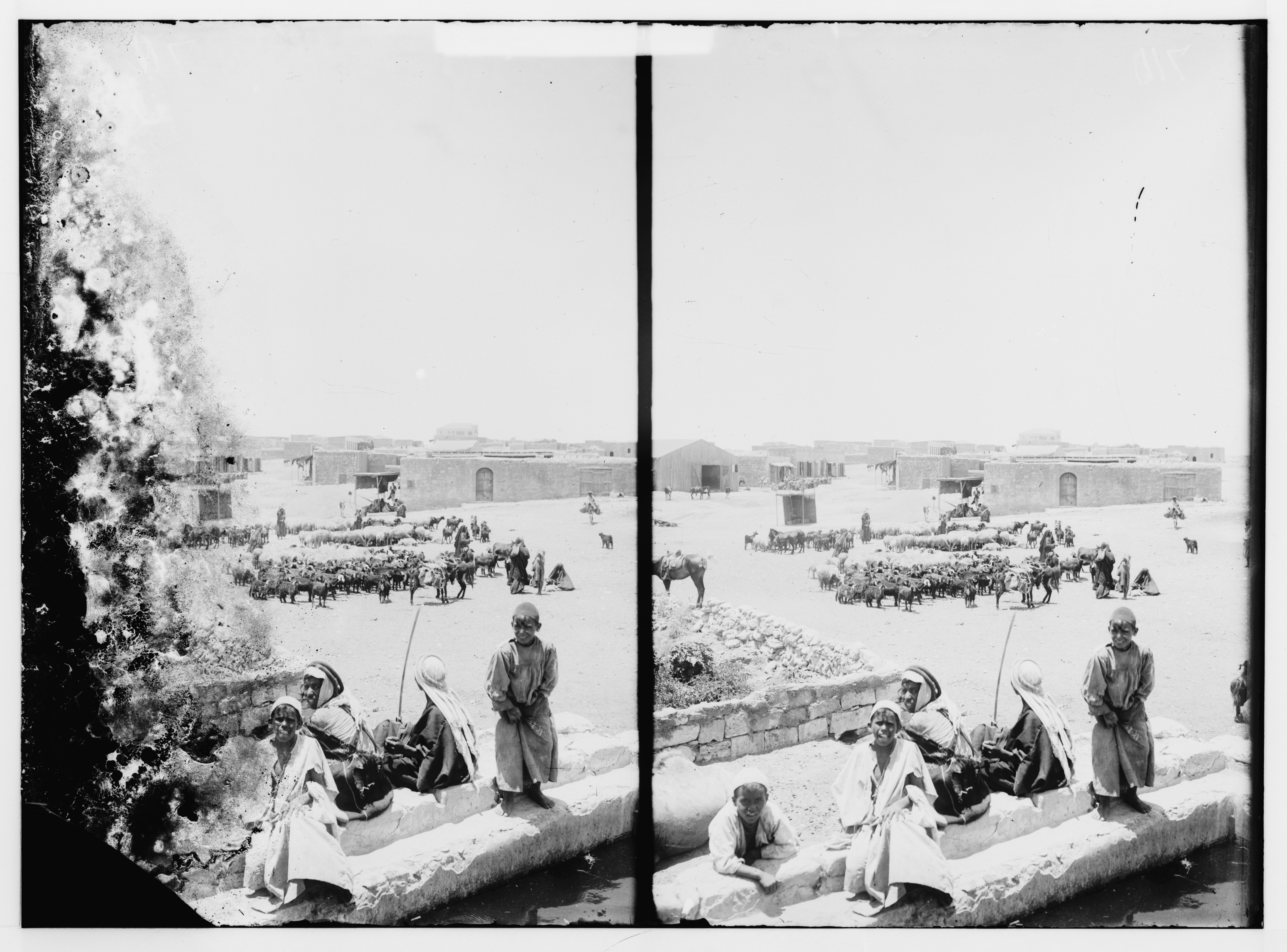 Stereoscopic photograph of a bustling city scene with people, horses, and carriages in a historical setting.