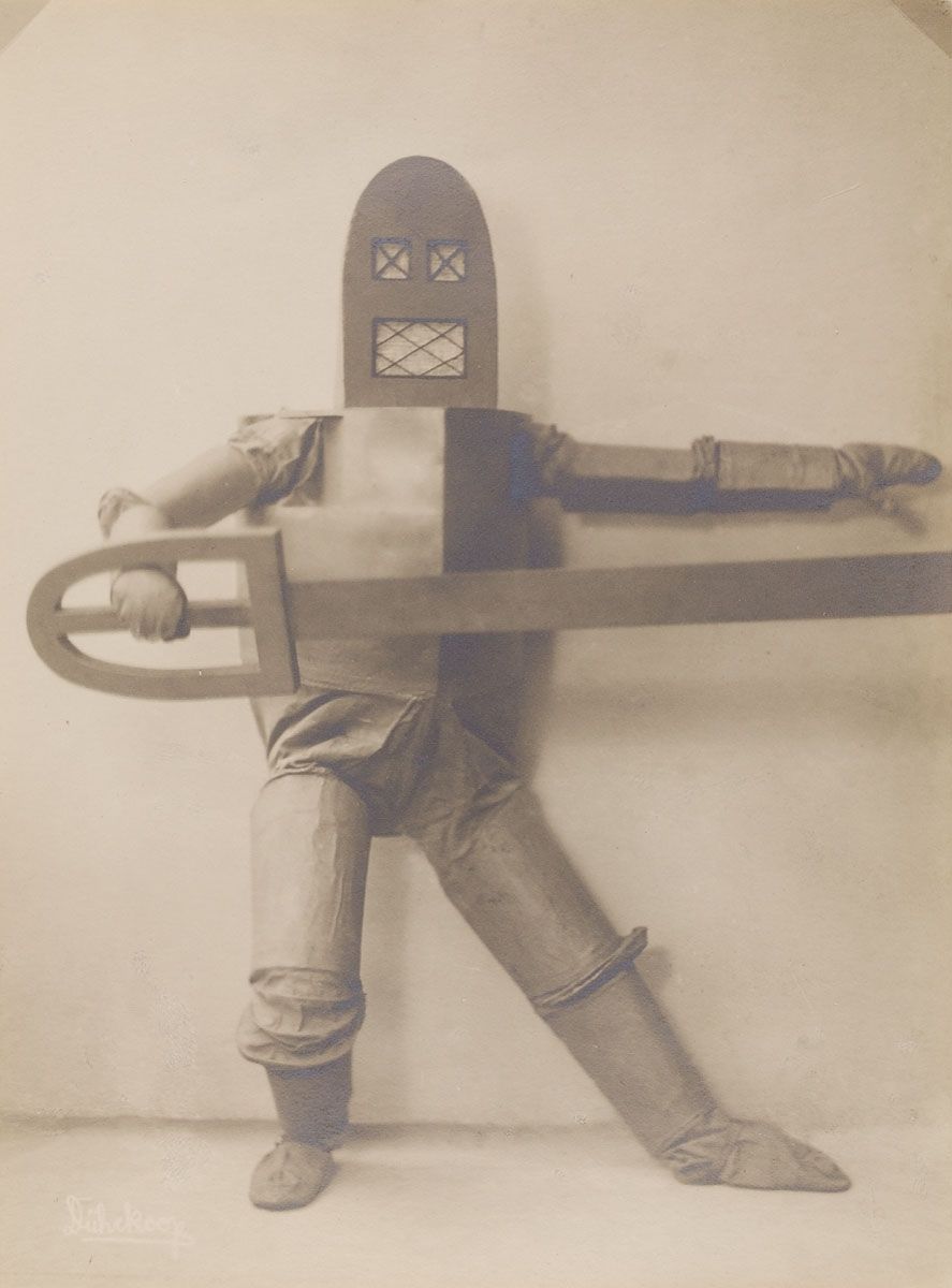 A vintage sepia-toned photograph of a person wearing a homemade robot costume.