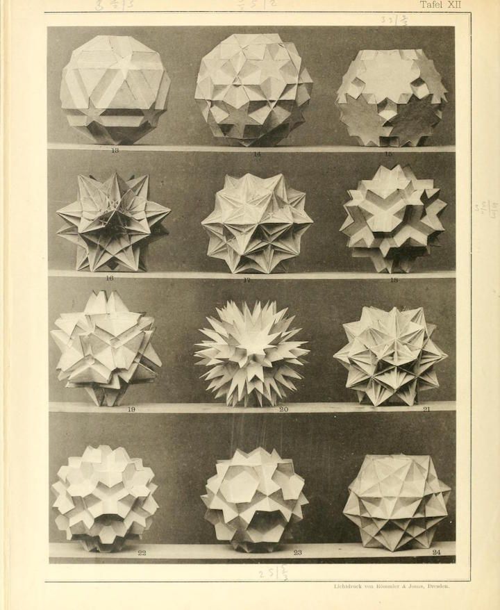 A black and white photograph of 12 numbered paper models arranged in a 3x4 grid. The models are geometric shapes resembling stars or spheres with many points.