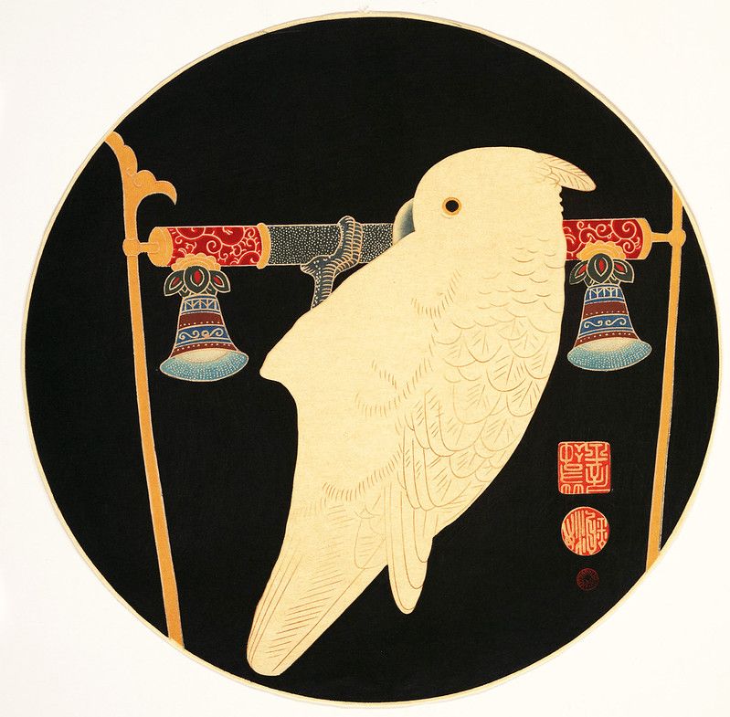 A circular Japanese-style painting featuring a pale yellow cockatoo perched on a bar supported by ornate gold poles with bell-shaped ornaments. A red seal with characters is visible to the right of the bird, all set against a deep black background.