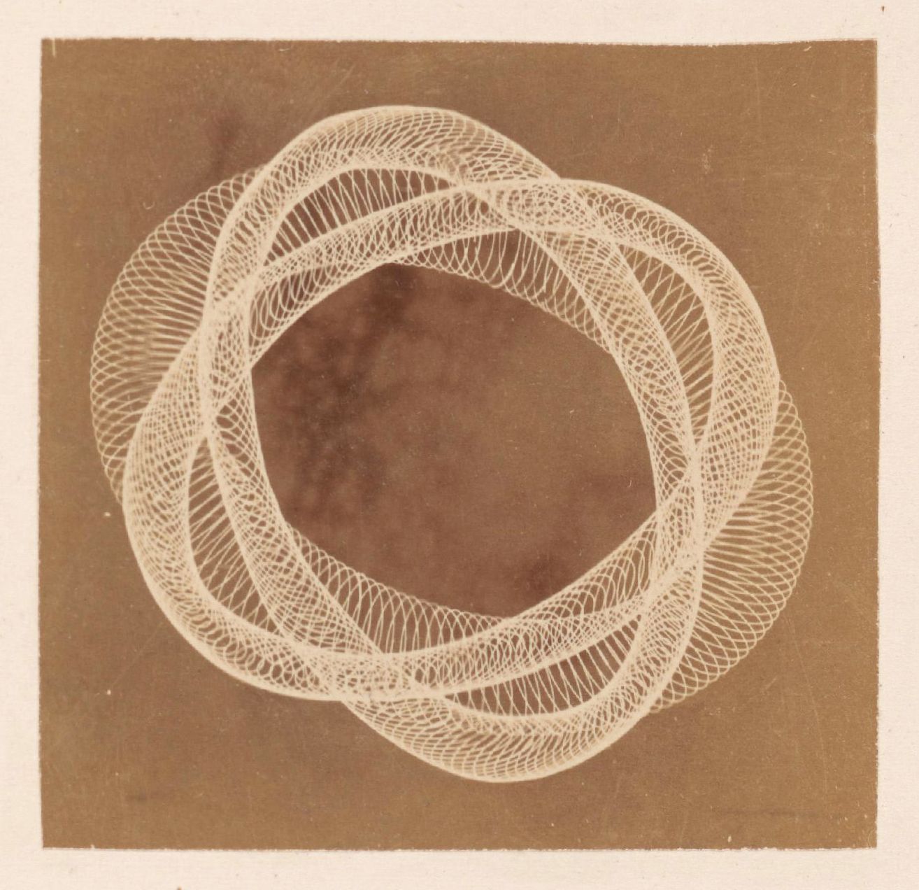 Sepia-toned photograph of a circular pattern created by numerous thin, pale lines spiraling and intertwining.