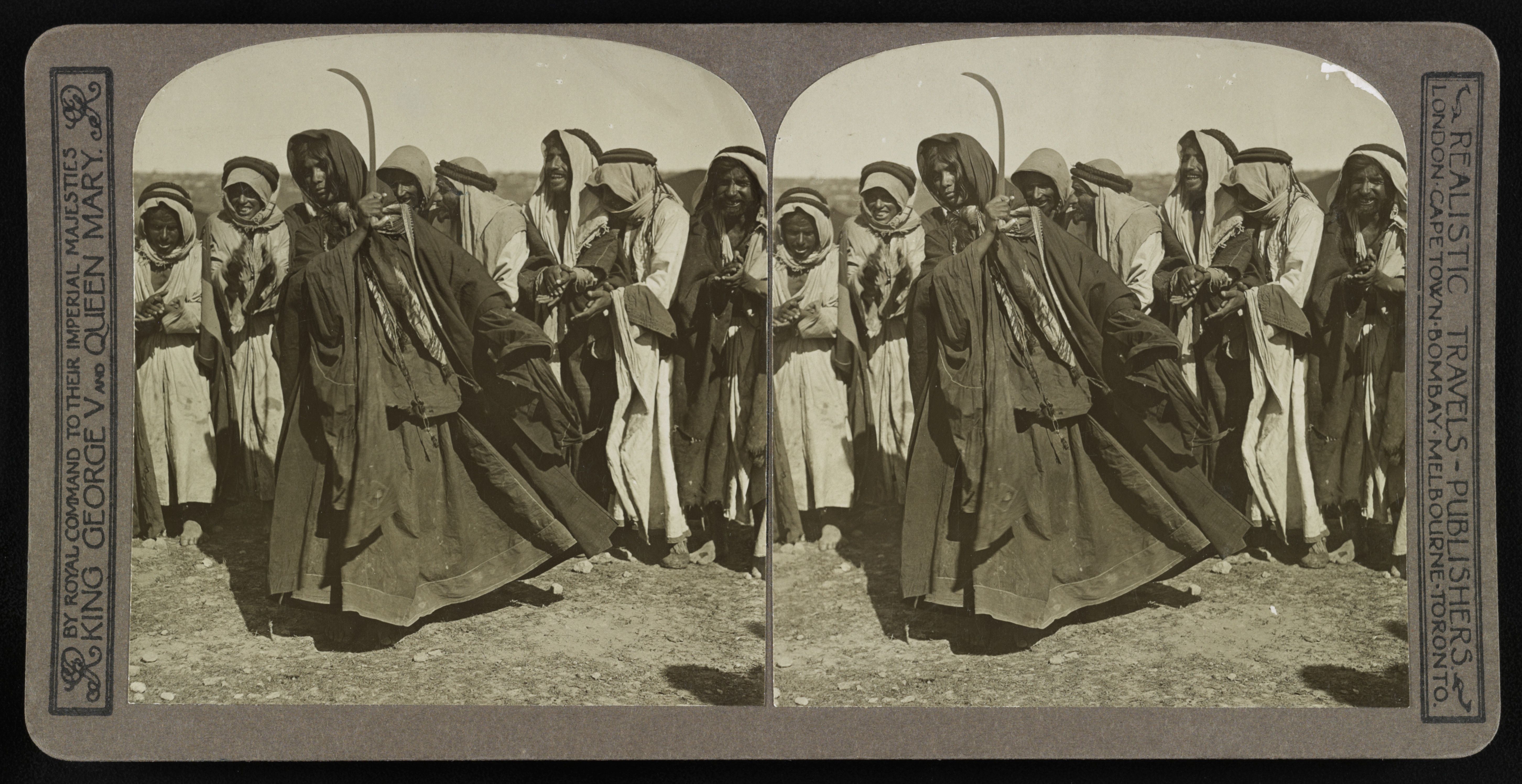 Stereoscope card depicting a group of men in traditional clothing holding scythes in a desert landscape.