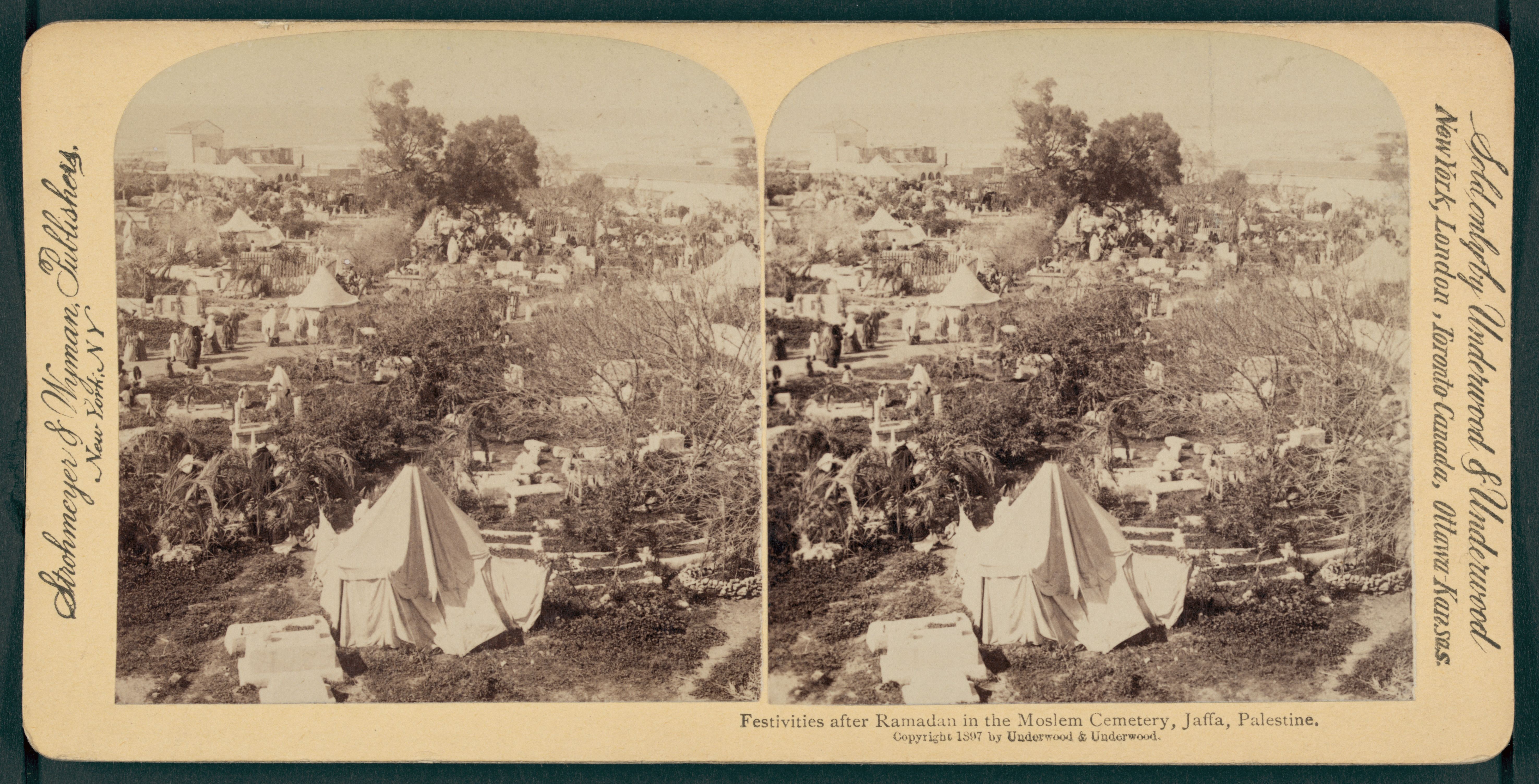 Stereoscopic photograph of a crowded Muslim cemetery in Jaffa, Palestine, during Ramadan festivities. The foreground is filled with tombstones and conical structures, while a large crowd of people gathers among them. The background shows trees and buildings.