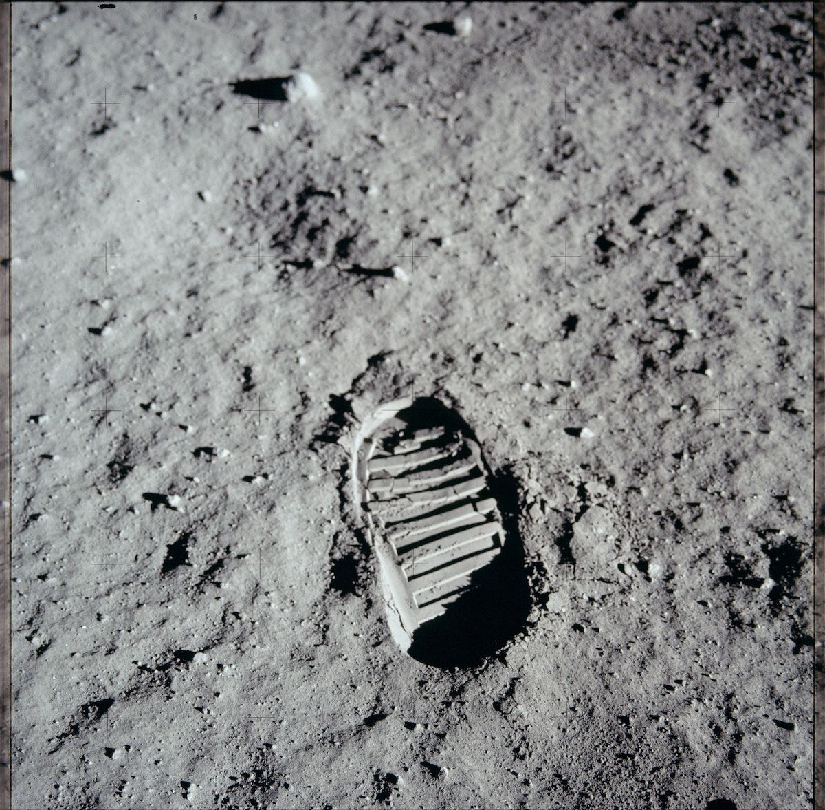 A black and white photograph of an astronaut's footprint in the lunar dust.