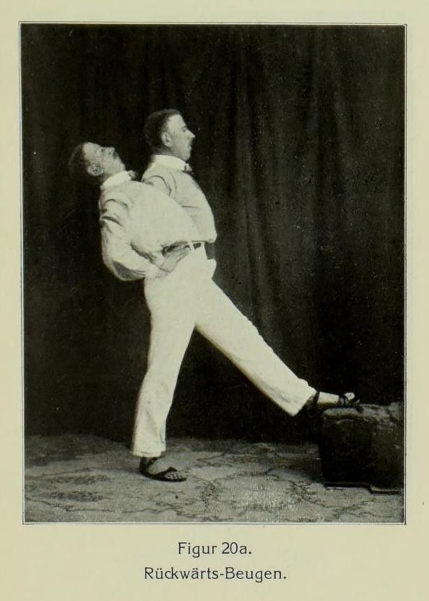 Vintage black and white photograph of two men performing a back bending gymnastic pose.