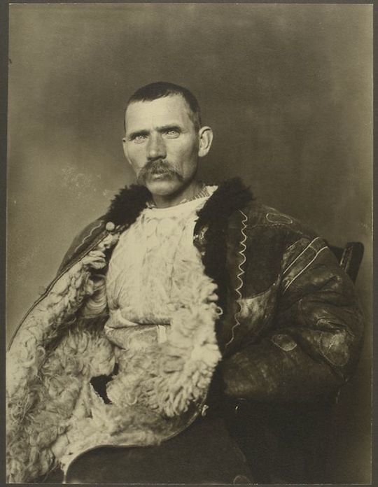 Sepia-toned portrait of a man in a fur-lined jacket.