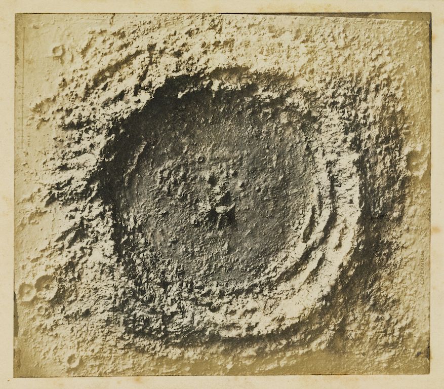 A textured, monochromatic drawing or sketch depicting a swirling, vortex-like form with dark, dense lines converging towards a central void.