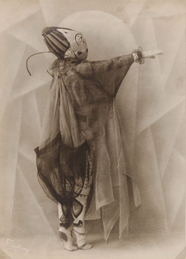Vintage illustration of a masked figure in a theatrical costume holding a sword.