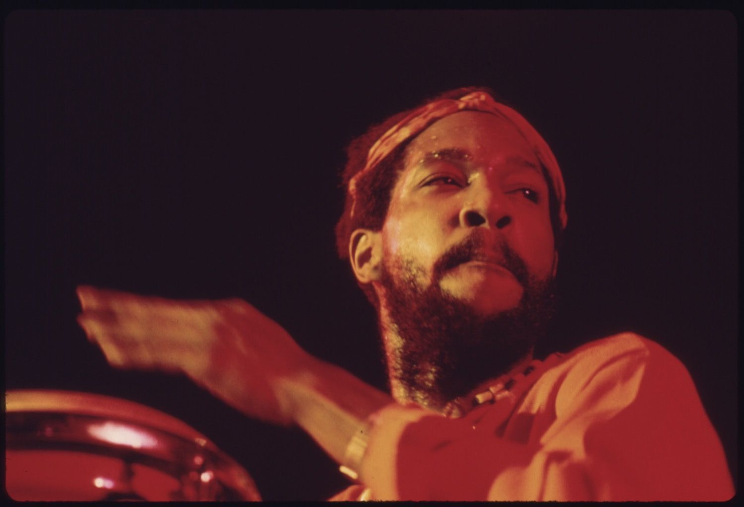 Close-up of a man playing the drums in a dark setting.