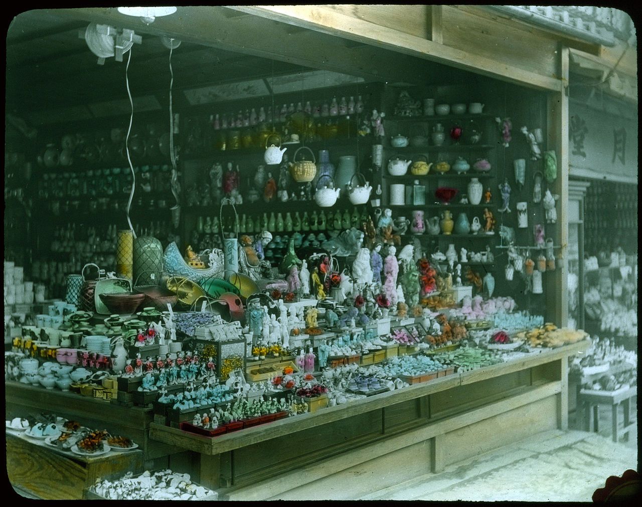 A crowded display of porcelain figurines and decorative items in a shop or market stall.