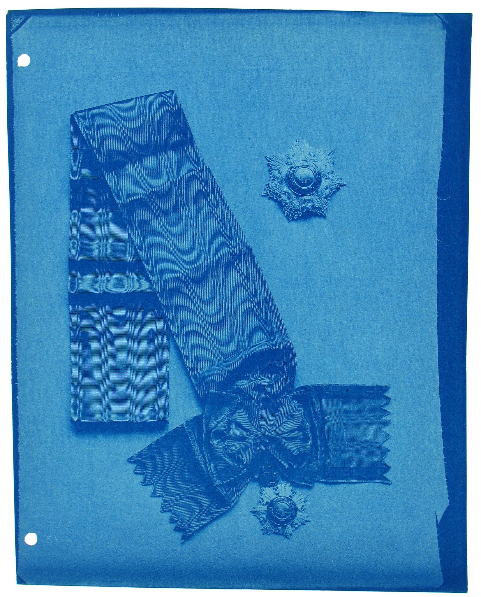 cyanotype photograph of ribbons and star-shaped medals