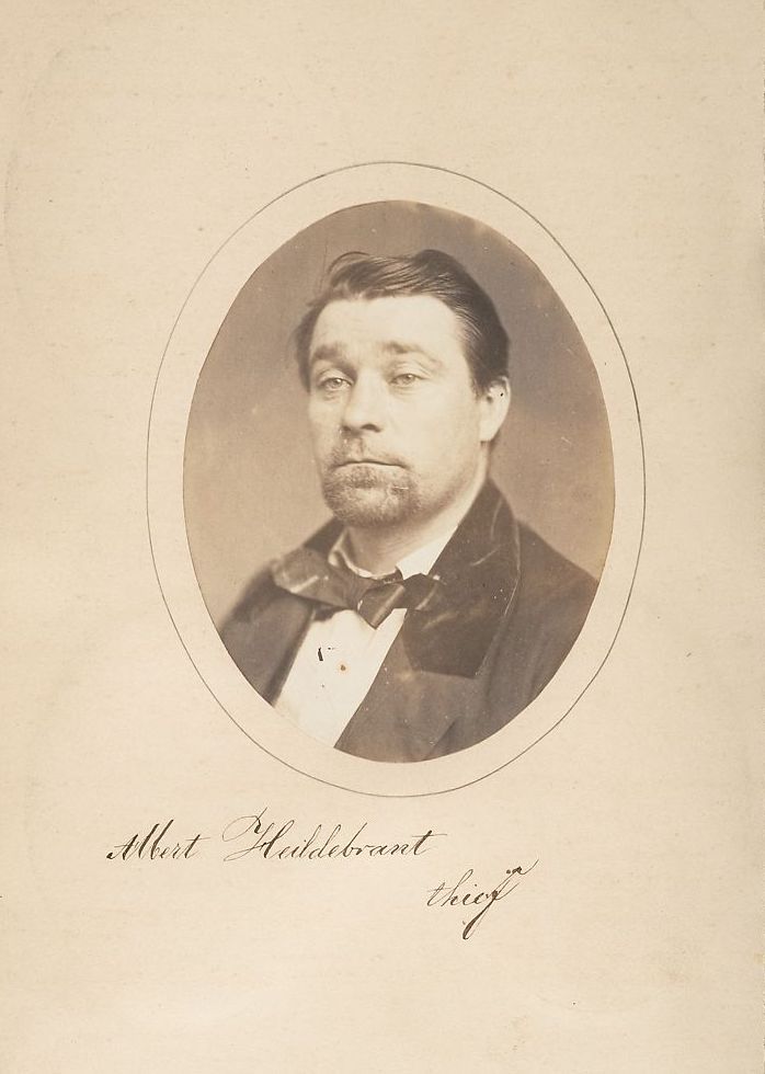 Vintage portrait of Albert Middlebrant, identified as a thief, in a dark suit with mustache and beard.