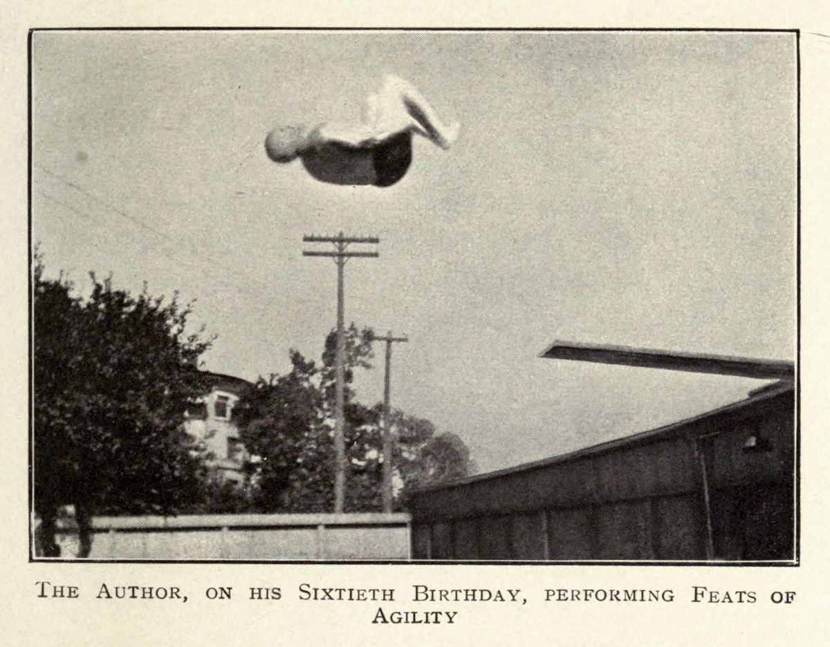 A vintage black and white photograph of a person performing a somersault in mid-air, with a residential scene in the background. The caption reads: 'The Author, on his Sixtieth Birthday, Performing Feats of Agility'.